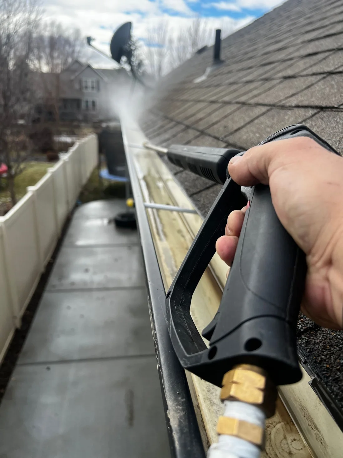 Cleaning debris from a gutter Debris being washed out of a gutter